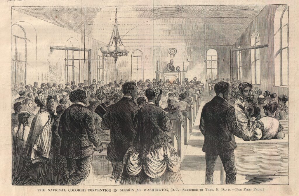 A historical engraving of the 1869 National Colored Convention in session in Washington, D.C. The image shows a convention from the back of the hall. The speaker is is in the far back of the image and is barely visible. The focus in on eight people in the back of the room paying attention not to the speaker but to a woman speaking to two young women. The scene is set in a large hall with arched windows, a central chandelier, and a clock on the wall. Caption in the image reads "The National Colored Convention in Session at Washington, DC—Sketched by Theo. R. Davis."